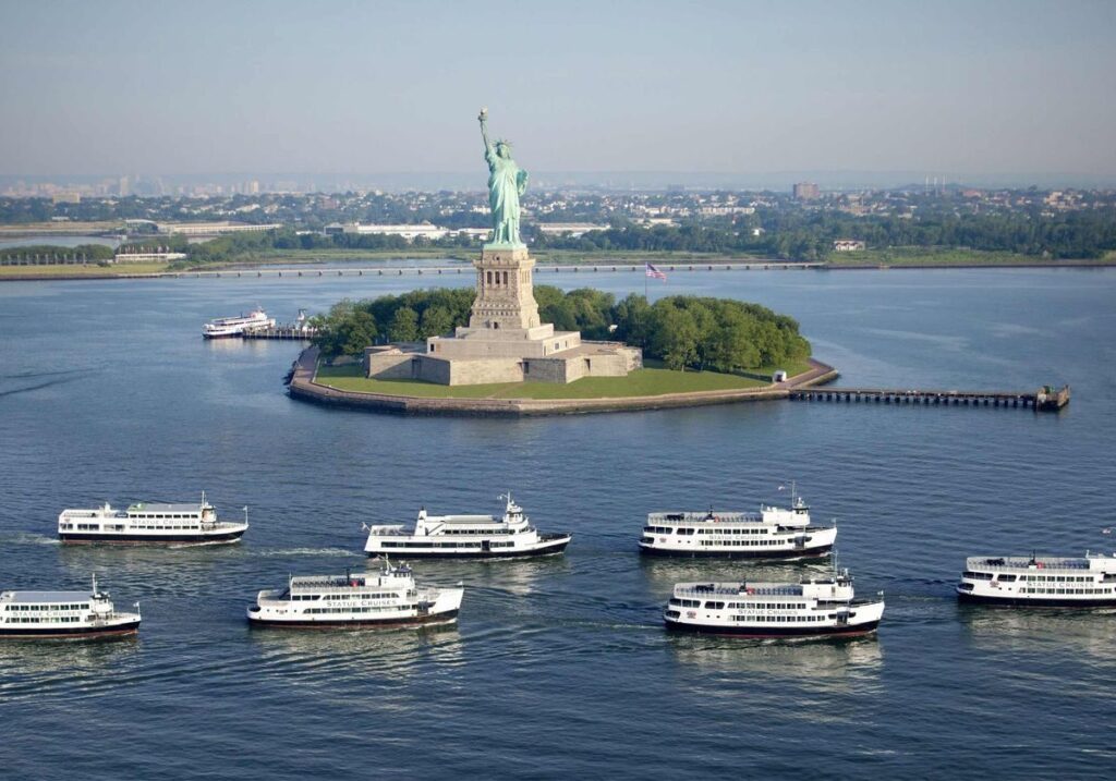 cruise ship passing the statue of liberty